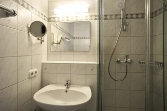 Beispielbadezimmer mit Dusche, Waschbecken und Spiegel